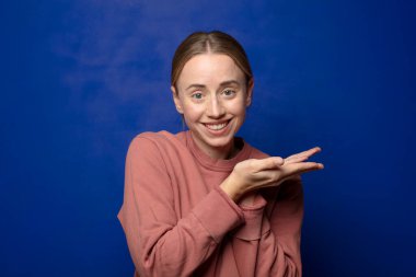 Sarışın kadın gülümsüyor, kendinden emin, başarılı ve mutlu hissediyor, fotokopi odasında konsept veya fikir gösteriyor.