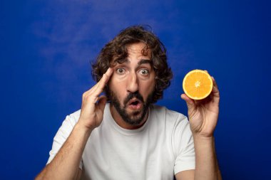 Portakal dilimli sakallı genç bir adam.