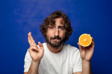 Portakal dilimli sakallı genç bir adam.