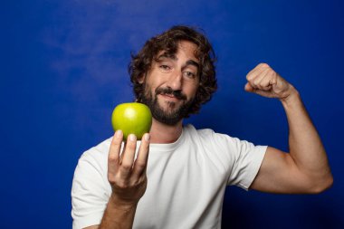 Elma tutan genç, sakallı adam.