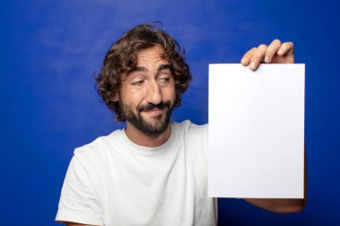 Genç, sakallı bir adam elinde bir kağıt tutuyordu.