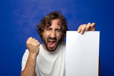 Genç, sakallı bir adam elinde bir kağıt tutuyordu.