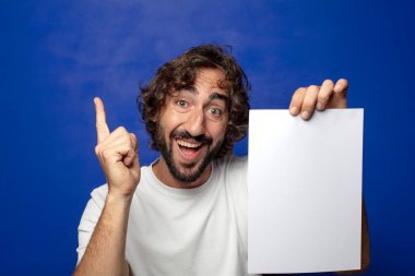 Genç, sakallı bir adam elinde bir kağıt tutuyordu.