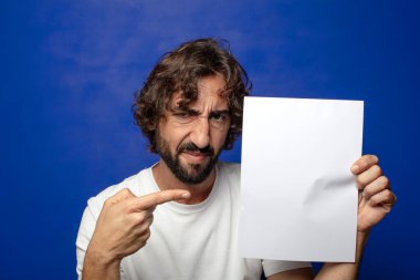 Genç, sakallı bir adam elinde bir kağıt tutuyordu.