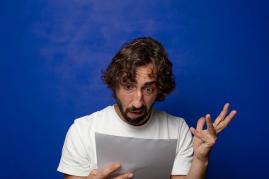 Genç, sakallı bir adam elinde bir kağıt tutuyordu.