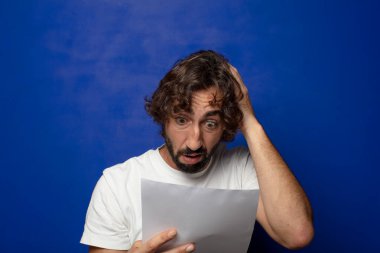 Genç, sakallı bir adam elinde bir kağıt tutuyordu.