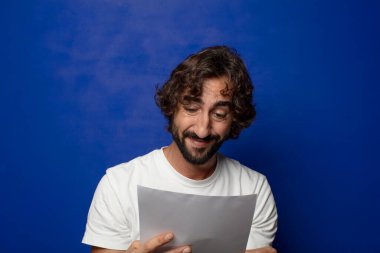 Genç, sakallı bir adam elinde bir kağıt tutuyordu.