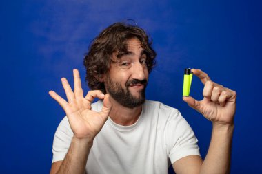 Genç, sakallı ve çakmaklı bir adam.