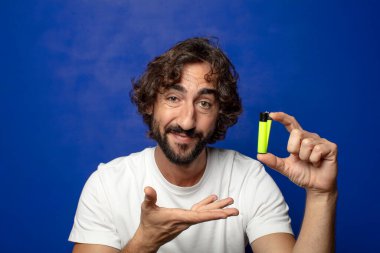 Genç, sakallı ve çakmaklı bir adam.