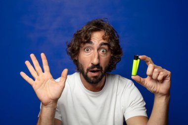 Genç, sakallı ve çakmaklı bir adam.