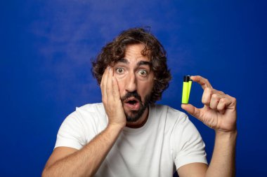 Genç, sakallı ve çakmaklı bir adam.