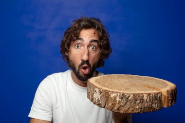 Genç, sakallı, ahşap kopya alanı olan bir adam.