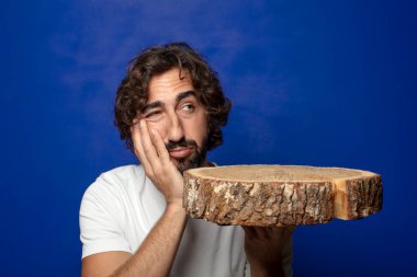 Genç, sakallı, ahşap kopya alanı olan bir adam.