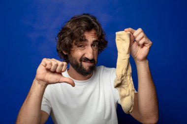 Kirli çorabı olan genç, sakallı bir adam.