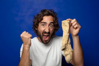 Kirli çorabı olan genç, sakallı bir adam.