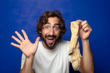 Kirli çorabı olan genç, sakallı bir adam.