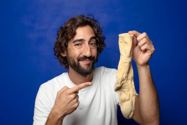 Kirli çorabı olan genç, sakallı bir adam.