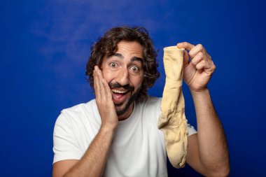 Kirli çorabı olan genç, sakallı bir adam.