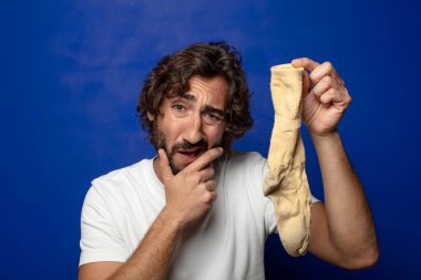 Kirli çorabı olan genç, sakallı bir adam.