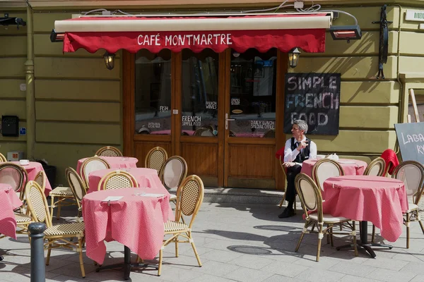 Člověk sedí u stolu v Café Montmartre v centru města Vilnius, Litva. — Stock fotografie