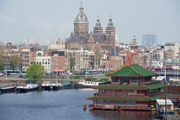 Pohled do města Amsterdamu s kanálem, historických budov a Bazilika svatého Mikuláše v Amsterdamu, Nizozemsko. — Stock fotografie