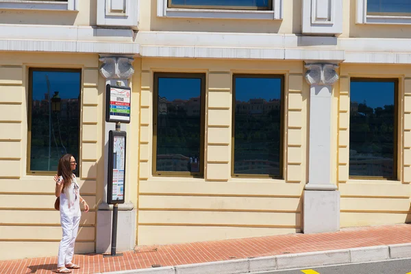 Mujer espera un autobús en la parada de autobús en Mónaco, Mónaco . —  Fotos de Stock