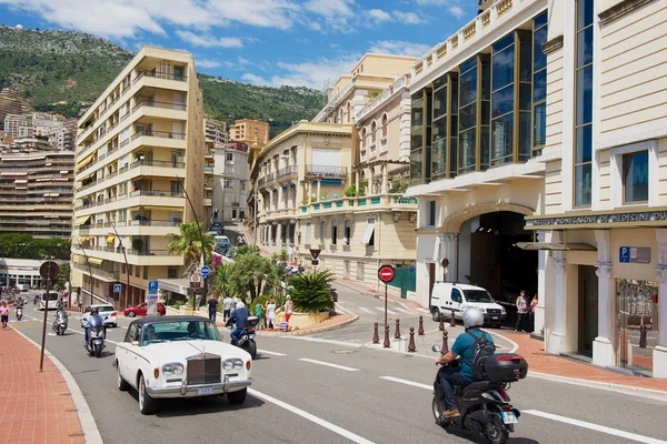 Cars and motorbikes pass by the street in Monaco.