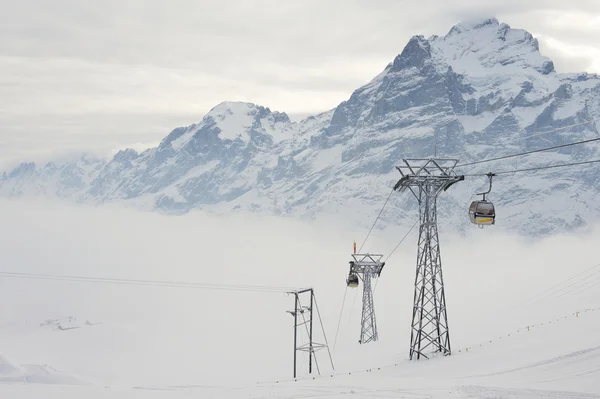 Cable car gondolas move skiers uphill at the ski resort in Grindelwald, Switzerland. — Stock Photo, Image