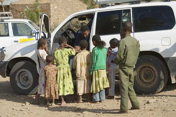 Los niños piden dinero a un conductor de coche en Adwa, Etiopía . — Foto de Stock