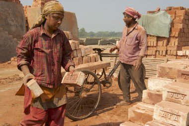 Dakka, Bangladeş'te bir fabrikada tuğla iki işçi taşımak.