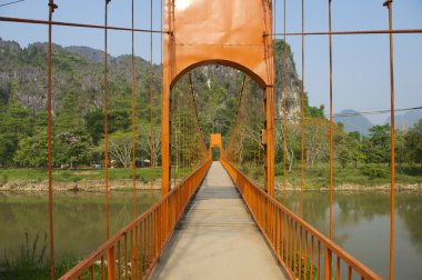 Turist Nam şarkı nehrin karşısındaki yaya köprüsü şehir Vang Vieng, Laos odaklı..