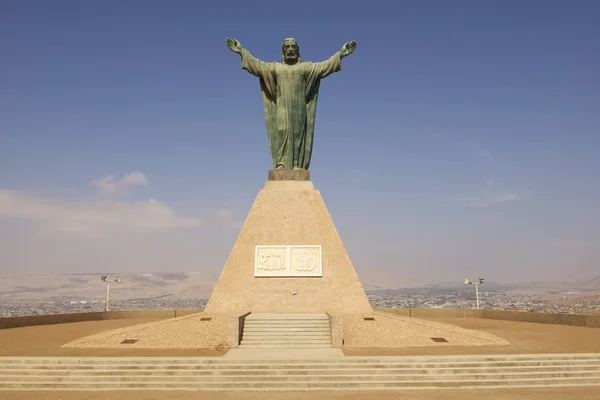 ARICA, CHILE - 20 DE OCTUBRE DE 2013: Monumento al Cristo de la Paz, con los escudos de armas peruanos y chilenos en el cerro El Morro en Arica, Chile . — Foto de Stock