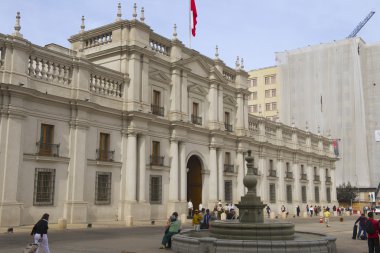 People walk in front of the La Moneda presidential palace in Santiago, Chile.