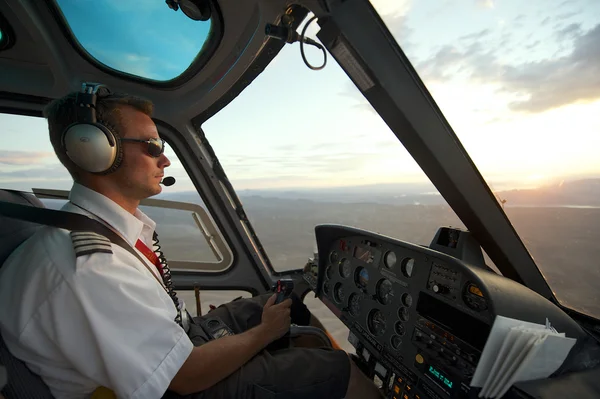 Uomo piloti elicottero al Grand Canyon al tramonto circa Las Vegas, Stati Uniti . — Foto Stock