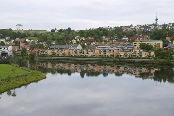 Lakónegyedében található épületek tükrözik Nidelva-folyó egy felhős napon, Trondheim, Norvégia. — Stock Fotó