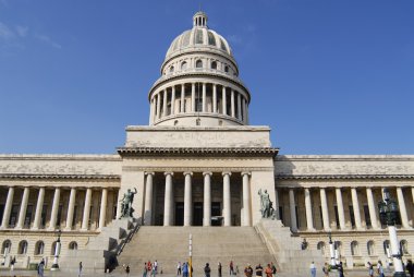 People walk in front of the Capitolio building in Habana, Cuba. clipart