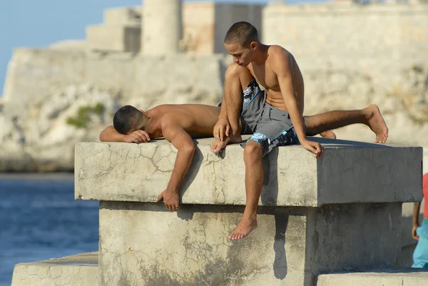 Giovani che prendono il sole alla diga Malecon a L'Avana, Cuba . — Foto Stock