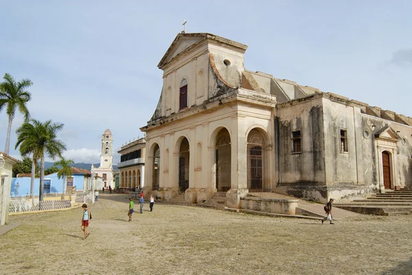 La gente camina frente a la Iglesia de la Santísima Trinidad en Trinidad, Cuba . —  Fotos de Stock