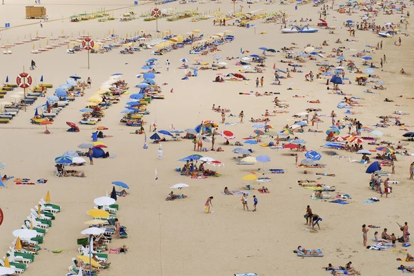 La gente prende il sole sulla spiaggia Praia da Rocha a Portimao, Portogallo . — Foto Stock