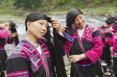 Women brush and style hair in Longji, China. clipart