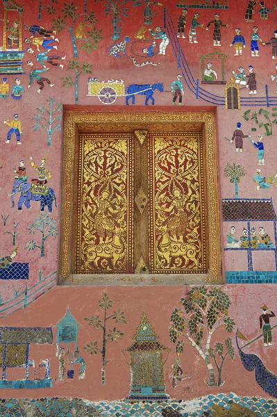 Внешняя стена с красивой мозаикой и покрашенным золотом окном павильона в храме Xieng Thong в Луангпрабанге, Лаос . — стоковое фото
