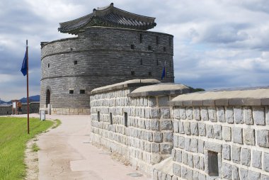 Tourist explores Hwaseong fortress (Brilliant Fortress) and tower in Suwon, South Korea. clipart