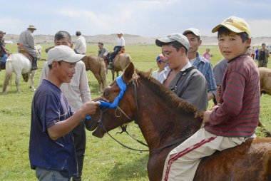 Erkekler kazanan at Harhorin, Moğolistan yaklaşık dizgin mavi şerit eklemek.