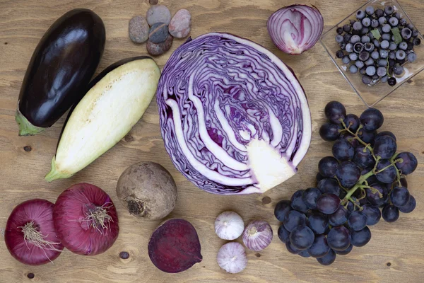 Set of vegetables and berries on aged wooden background: onion, eggplant, cabbage, beetroot, garlic, grape, black currant. — Stock Photo, Image