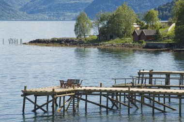 Chairs at the pier of a fjord in Balestrand, Norway. clipart