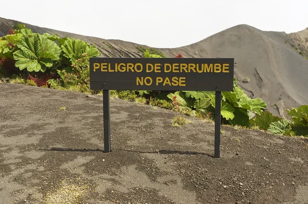 Sign "Danger of land slide, do not pass" at the side of the Irazu volcano crater in the Cordillera Central close to the city of Cartago, Costa Rica. — Stock Photo, Image