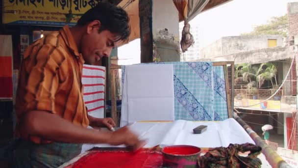 Člověk vytváří razítko tisku hadřík na workshop na nový trh v Dháce, Bangladéš. — Stock video