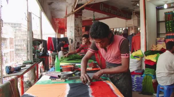 人々 がダッカ、バングラデシュの新しい市場でのワーク ショップでスタンプ プリント布を生成します。. — ストック動画