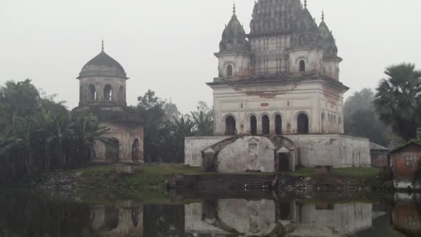 外部的湿婆庙 Puthia，孟加拉国一个多雾的早晨把尖刀萨加尔湖中反思. — 图库视频影像
