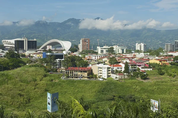 Visa till National Stadium och byggnader med berg i bakgrunden i San Jose, Costa Rica. — Stockfoto